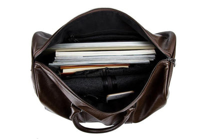 Detailed view of sturdy zippers on a men's leather duffel, lightweight travel carry-on.