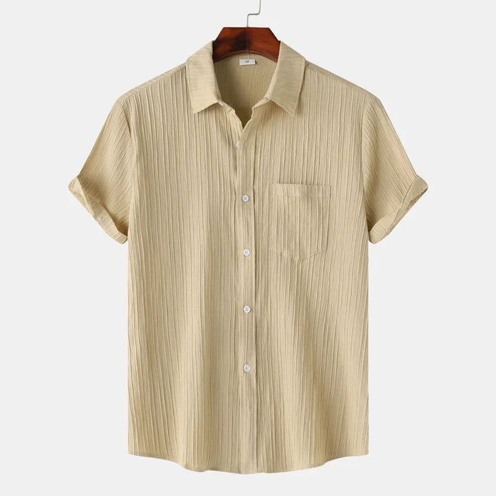 Short-sleeve men's button-down shirt with coastal vibes. Lightweight & comfortable for versatile summer fashion.