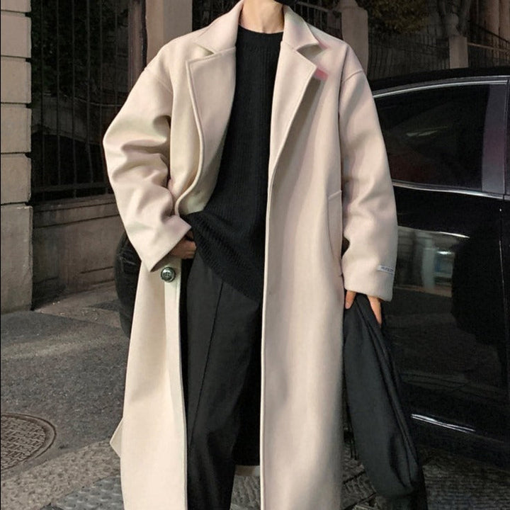 Front view of a men's black belted long overcoat, featuring classic trench coat design for ultimate elegance.