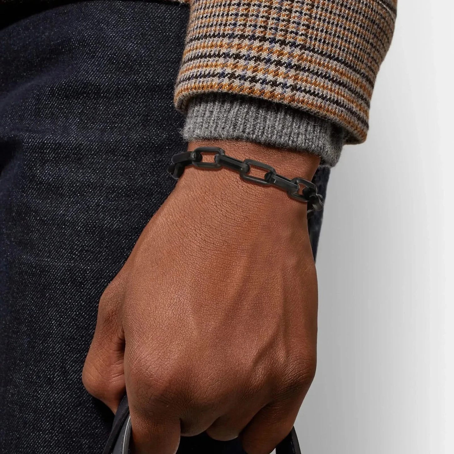 Men's luxury chain link bracelet on wrist, adding a bold and sophisticated touch to any outfit.