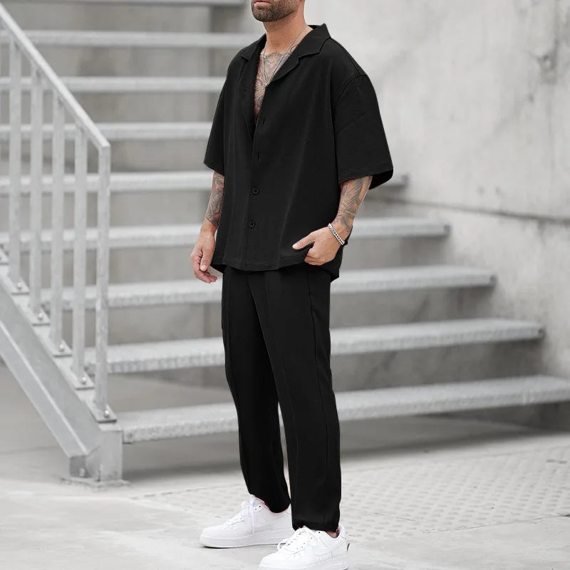 Elegant black men's button-up shirt and matching trousers. Luxury two-piece formal wear set.