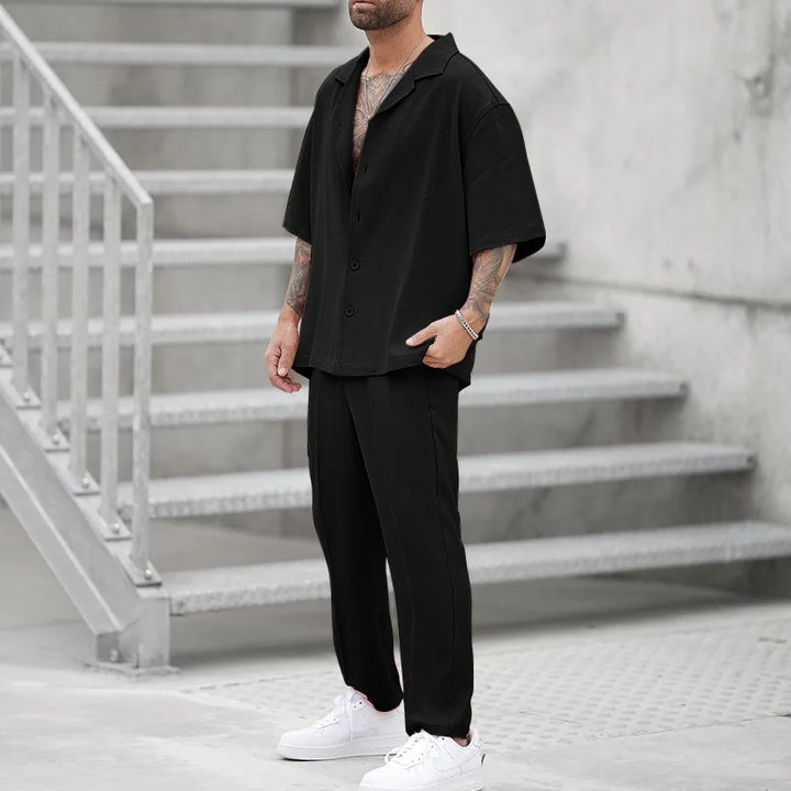 Elegant black men's button-up shirt and matching trousers. Luxury two-piece formal wear set.