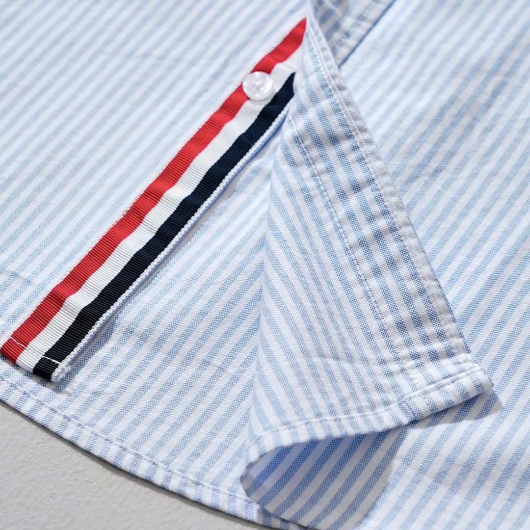 Close-up of Men's Milo striped casual shirt, showing blue & gray pattern. Lightweight fabric for men's summer style.