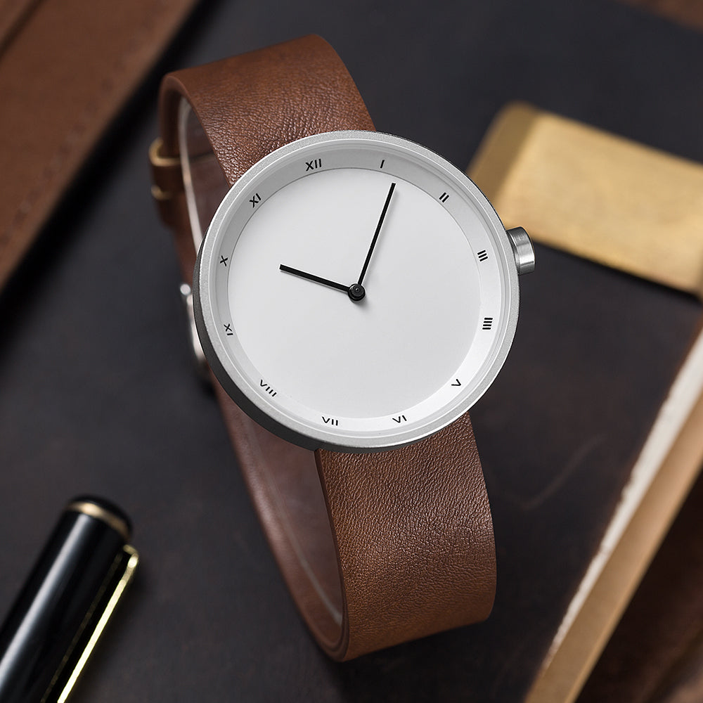 Men's modern minimalist watch with sleek black dial, silver case, and roman numerals.