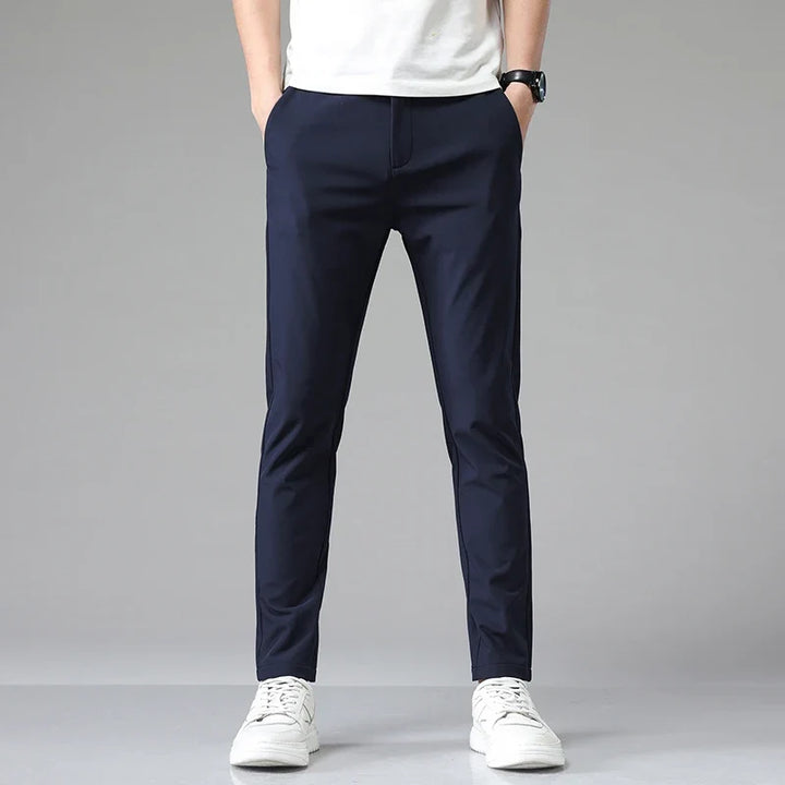 Detail shot: waistband and closure of men's modern straight fit performance pants. Tailored design.
