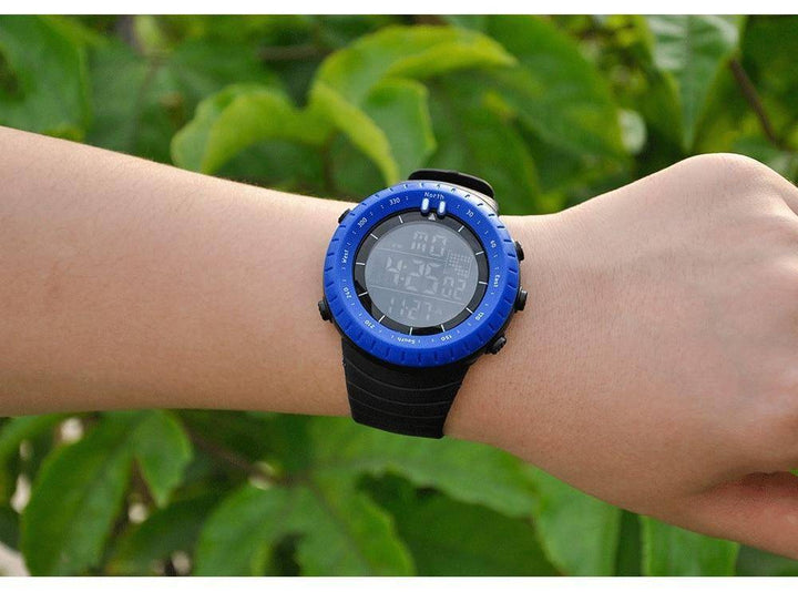 High-angle shot of a men's digital watch with altimeter and silicone band, ready for adventure gear