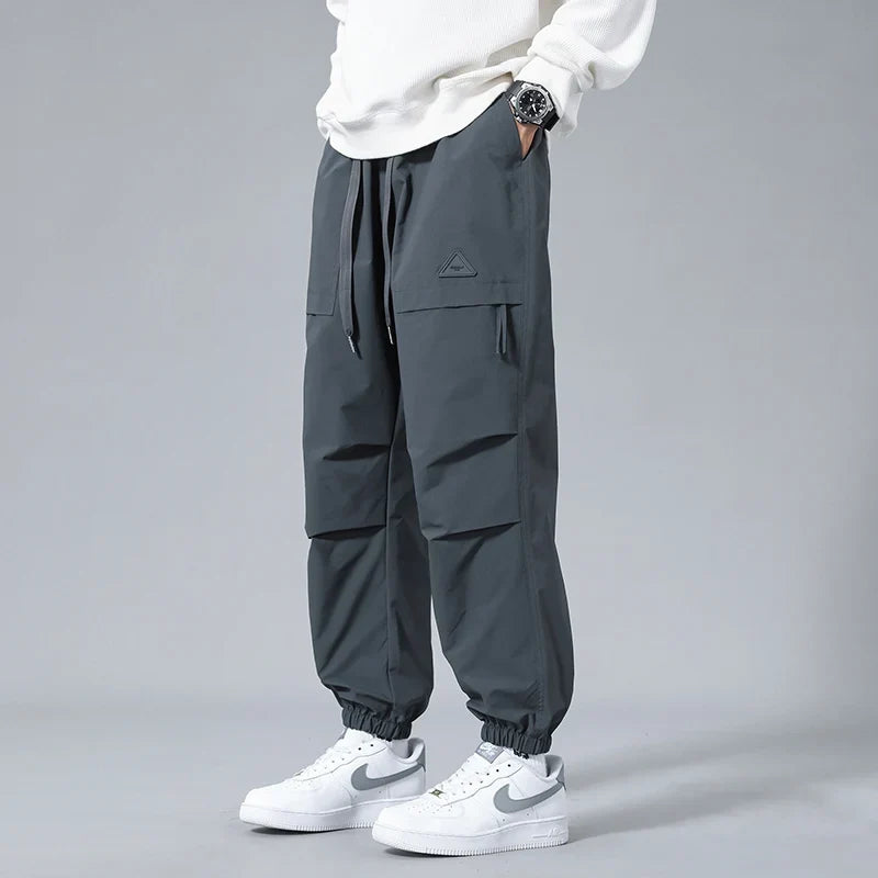 Men's Performance Utility Joggers with dynamic fit, tapered legs, cuffed ankles, and multiple zippered pockets.
