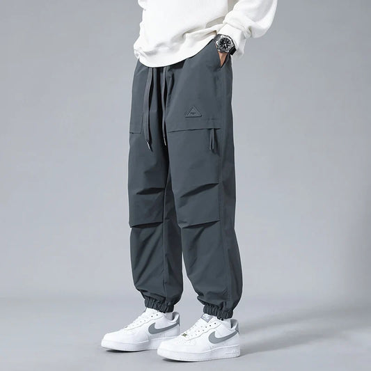 Men's Performance Utility Joggers with dynamic fit, tapered legs, cuffed ankles, and multiple zippered pockets.