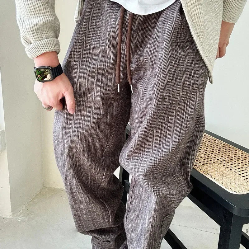 Detailed view of men's pinstripe drawstring pants, showcasing the fabric texture and relaxed, comfortable design.