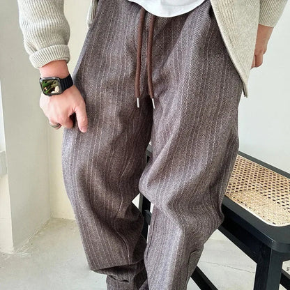 Detailed view of men's pinstripe drawstring pants, showcasing the fabric texture and relaxed, comfortable design.
