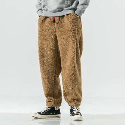 Close-up: Plush sherpa fleece texture on men's warm jogger pants, soft, cozy winter loungewear.