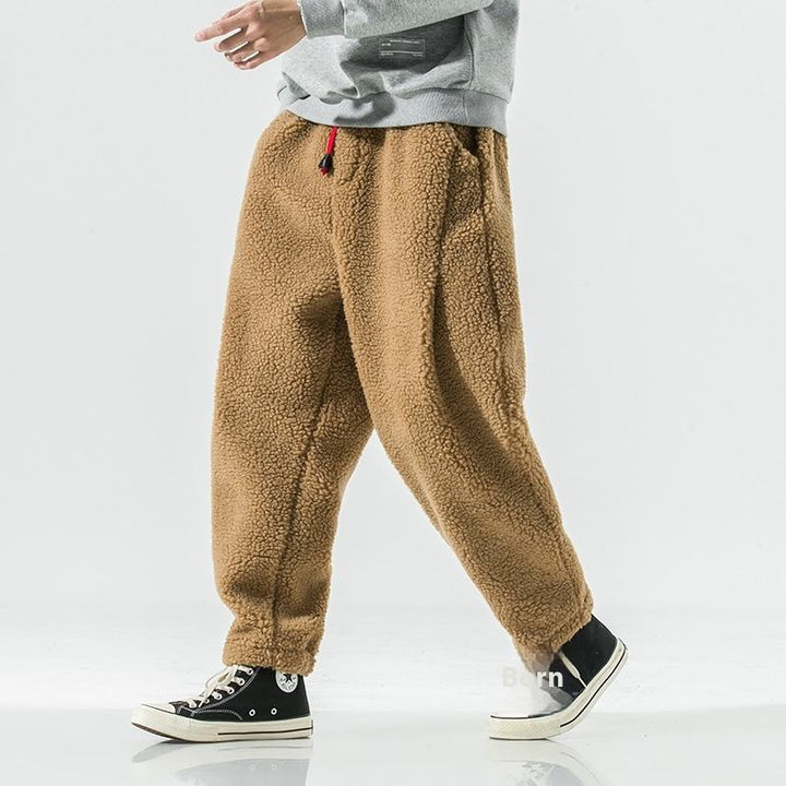 Man wearing relaxed fit plush sherpa fleece joggers, ideal warm loungewear for casual comfort & winter.