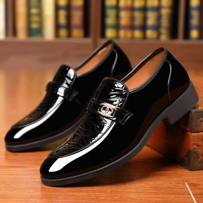 Elegant men's dress shoes: polished black slip-on loafers with unique croc texture.