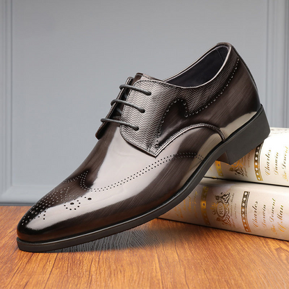Top-down view of men's sleek black brogue oxford shoes, showcasing polished leather and classic design.