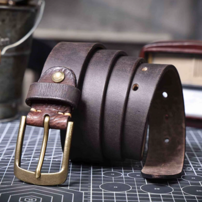 Stack of durable men's cowhide leather belts in varying brown shades. Classic waist accessories.