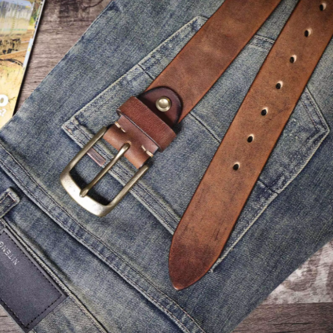 Rolled men's premium brown cowhide leather belt, showcasing durable material and vintage style.