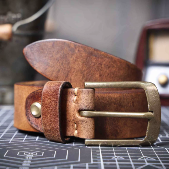Detailed stitching on a men's premium brown cowhide leather belt. Durable classic leather accessory.