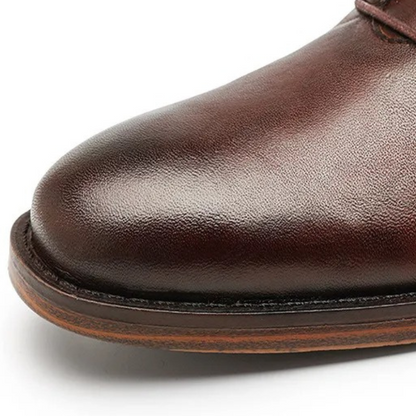 Close-up of men's black leather dress boot texture, showcasing premium material and craftsmanship.