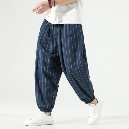 Model wearing men's pinstripe harem joggers, relaxed fit, styled for comfortable casual wear.
