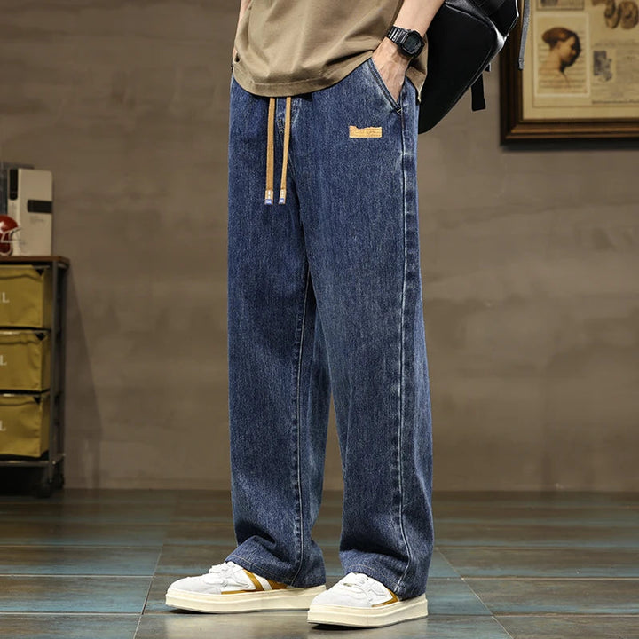 Men's relaxed fit indigo blue denim joggers with drawstring, perfect for comfortable everyday wear.