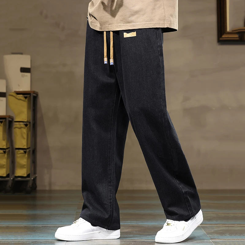 Men's apparel: Eclipse black relaxed fit denim joggers with a comfortable drawstring and wide leg.