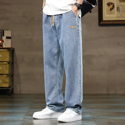 Man wearing eclipse black relaxed fit denim joggers, ideal for casual activities and everyday comfort.