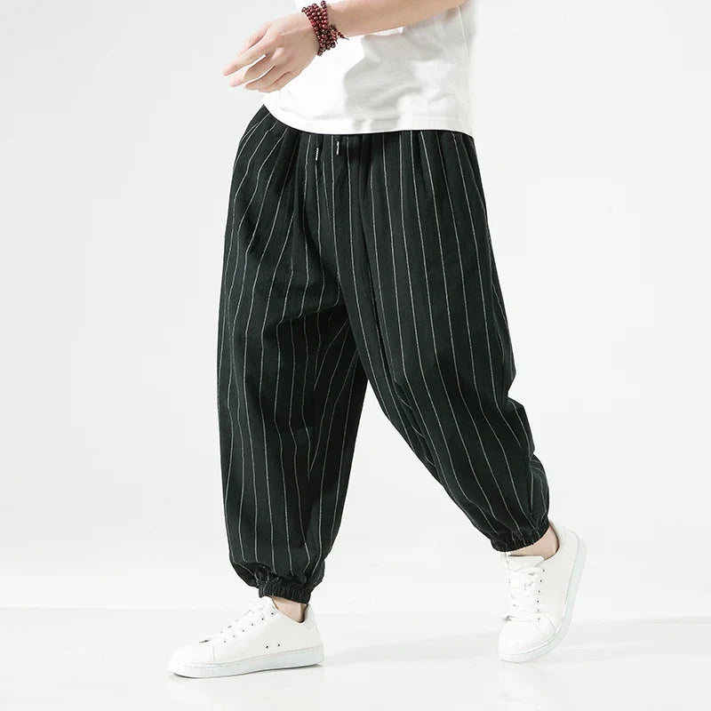 Man wearing dark grey relaxed fit pants, emphasizing the comfortable and versatile casual wear style.
