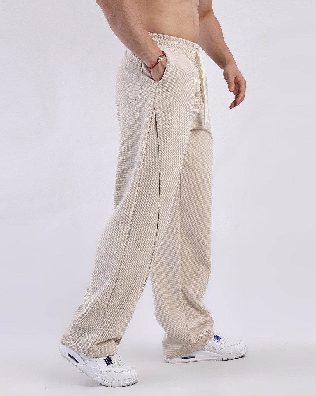 Relaxed fit men's waffle knit sweatpants, featuring a drawstring waist for adjustable, modern comfort.