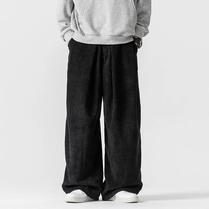 Detail of men's relaxed wide-leg trousers, highlighting the comfortable fit and practical drawstring waist.