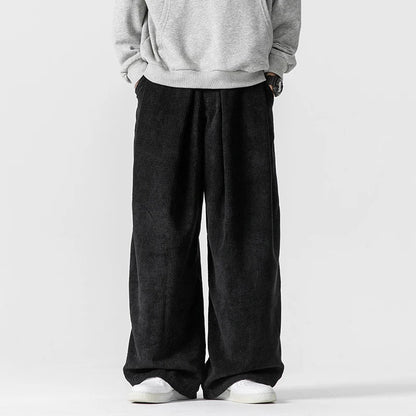 Detail of men's relaxed wide-leg trousers, highlighting the comfortable fit and practical drawstring waist.
