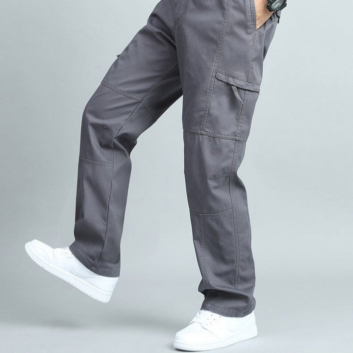 Olive green rugged men's cargo pants, multi-pocket design for outdoor utility and comfort.