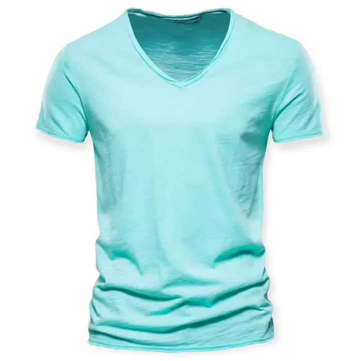 Stack of neatly folded men's V-neck t-shirts in various solid colors. Comfortable & versatile everyday basics.