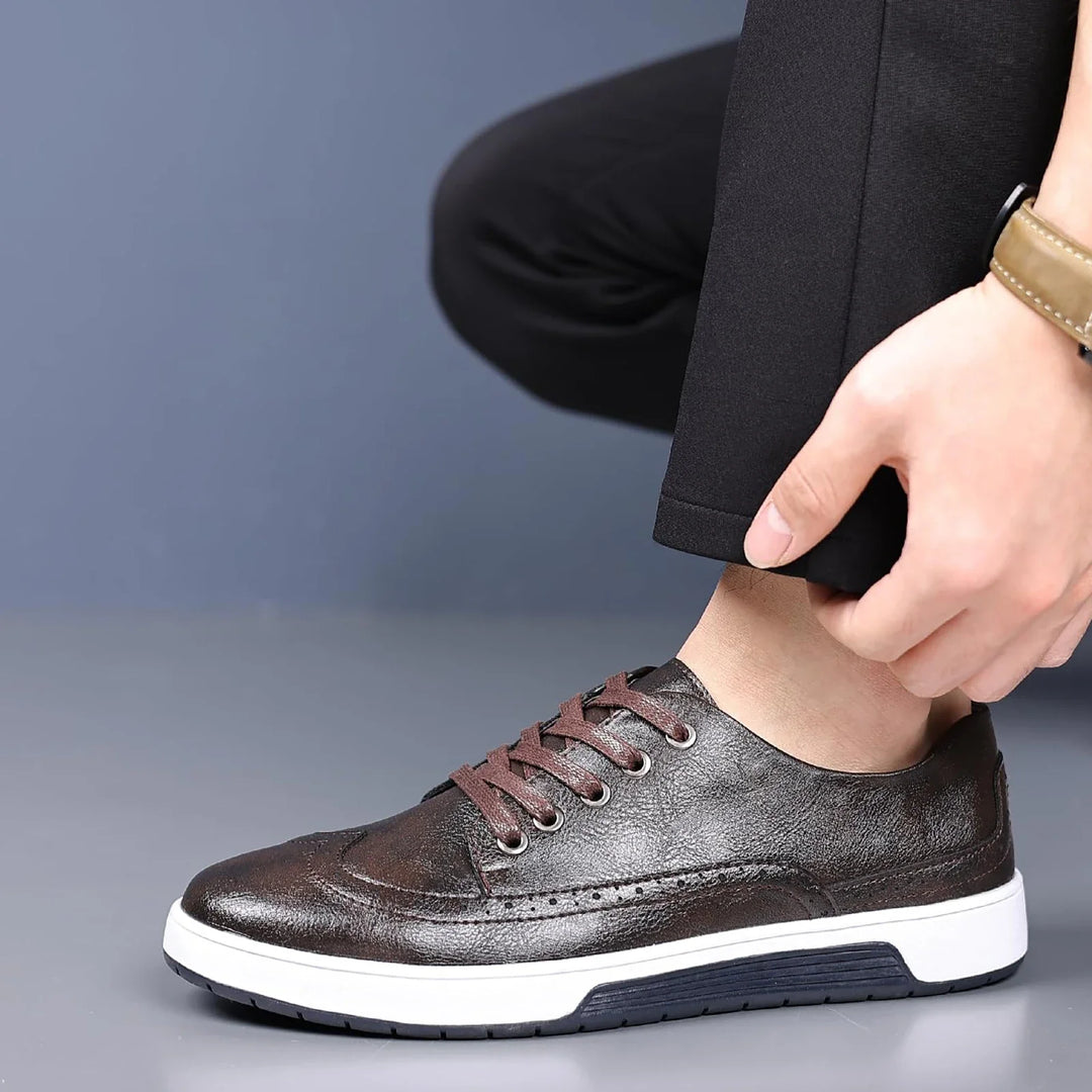 Closeup of men's versatile brogue sneakers in a charcoal grey, showing texture, perfect for dress casual.