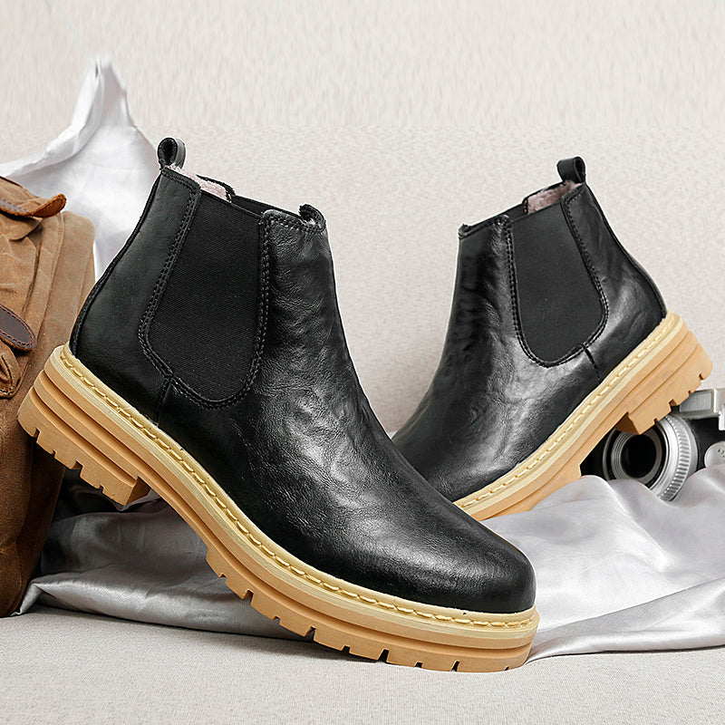Man wearing stylish brown Chelsea boots with jeans, showcasing a casual fashion look.