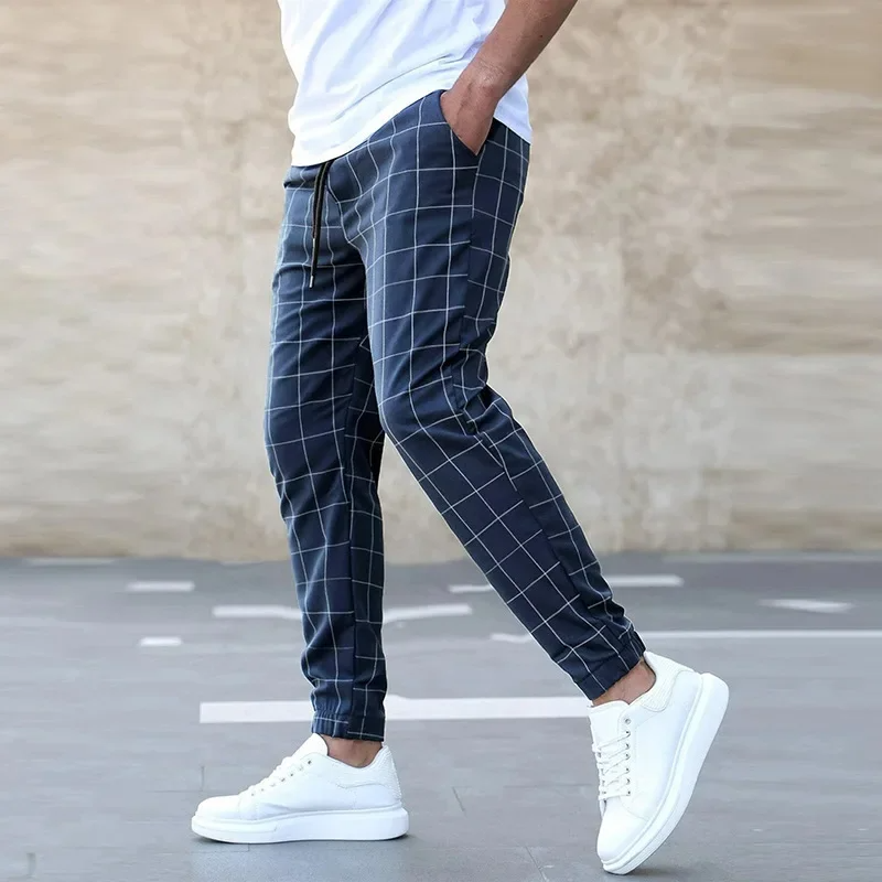 Modern men's tapered jogger pants with a stylish checkered pattern, great for casual street fashion.