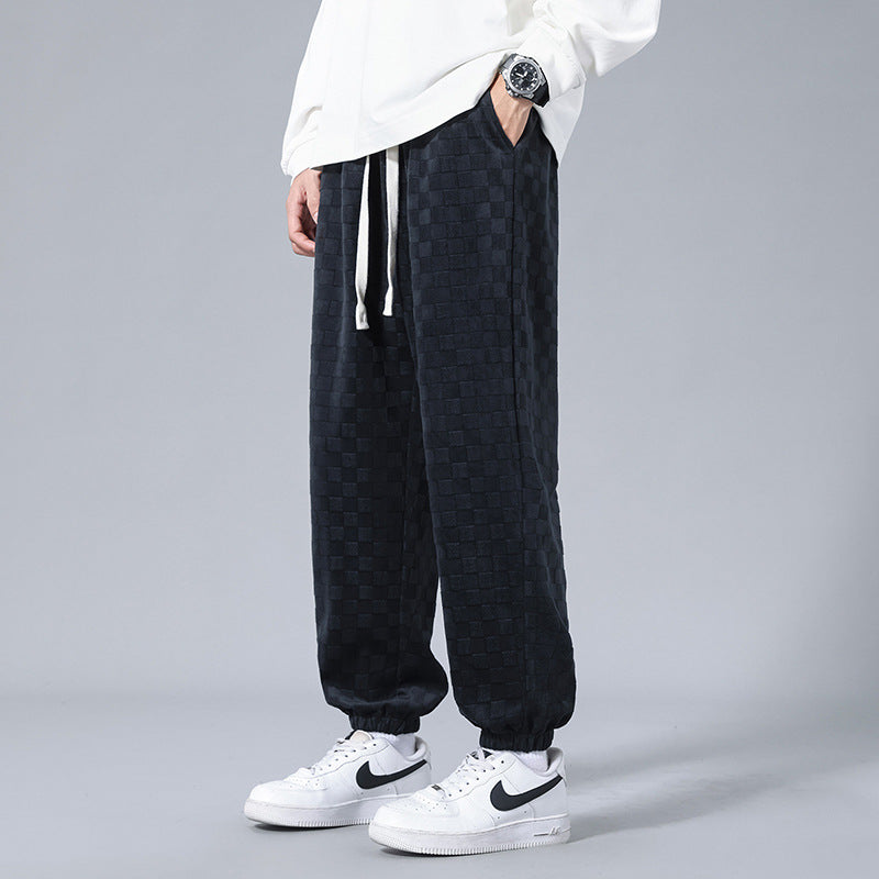 Stylish checkerboard pattern men's sweatpants with a relaxed fit, a key piece for modern streetwear fashion.