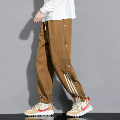 Comfortable men's snap track pants, perfect for athletic wear or casual street style. Versatile relaxed fit joggers.
