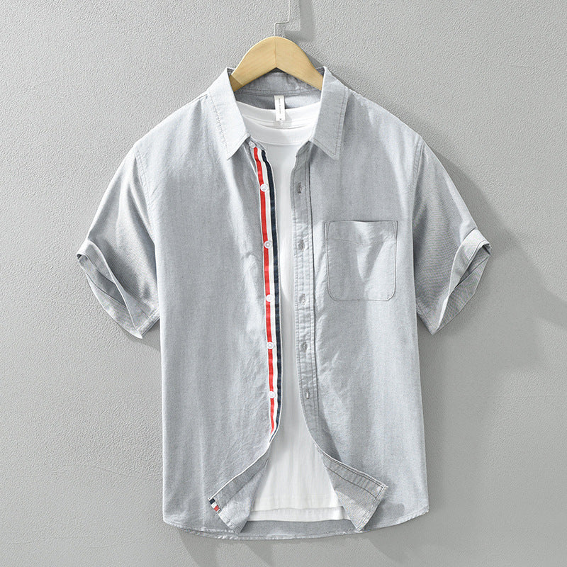 Close-up of lightweight, breathable men's casual button-up shirt fabric. Features a stylish striped pattern & quality buttons.
