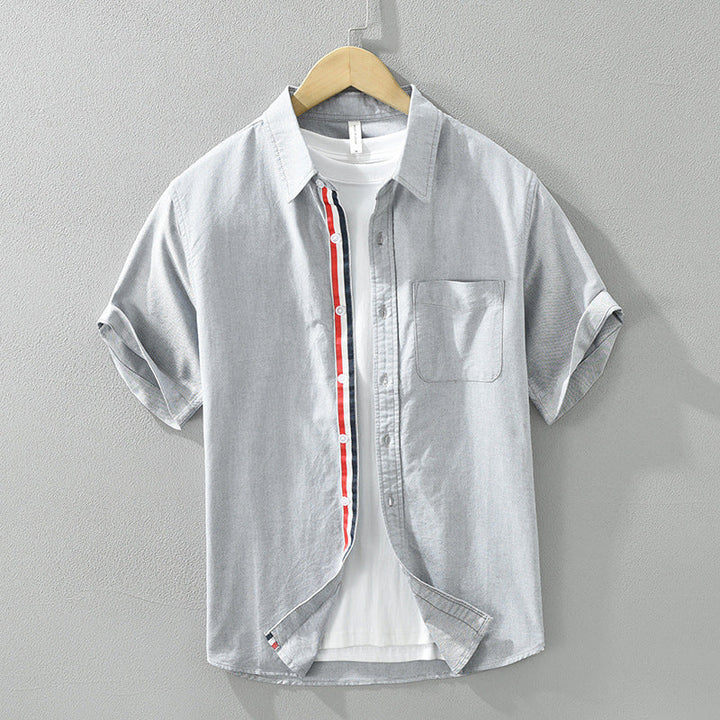 Close-up of lightweight, breathable men's casual button-up shirt fabric. Features a stylish striped pattern & quality buttons.