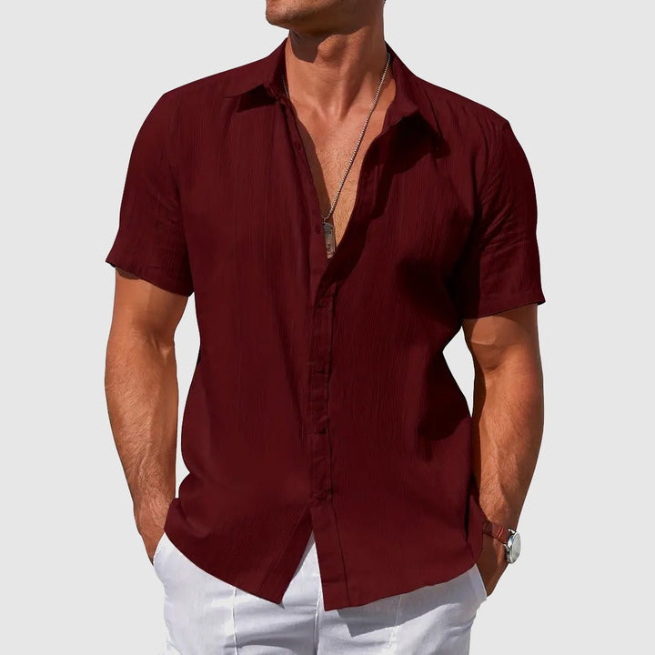 Model in a stylish men's textured short sleeve top, showcasing summer comfort & fashion.