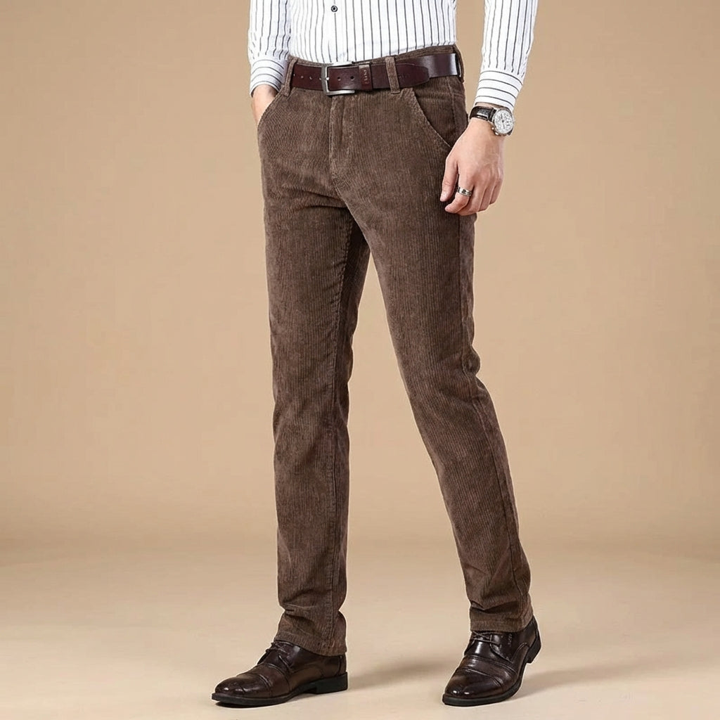 Close-up of premium brown corduroy fabric on men's tailored fit pants, highlighting texture & quality.