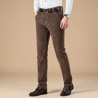 Close-up of premium brown corduroy fabric on men's tailored fit pants, highlighting texture & quality.