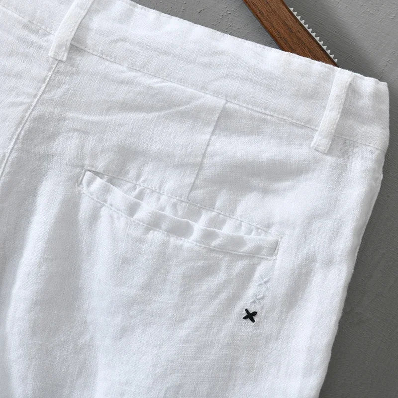 Stack of men's lightweight linen shorts in various colors, essential for a versatile warm weather wardrobe.