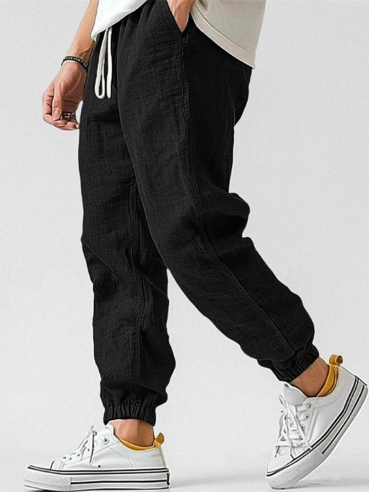 Men's casual joggers with a drawstring waist, tapered fit & cuffed ankles; ideal for spring & summer.