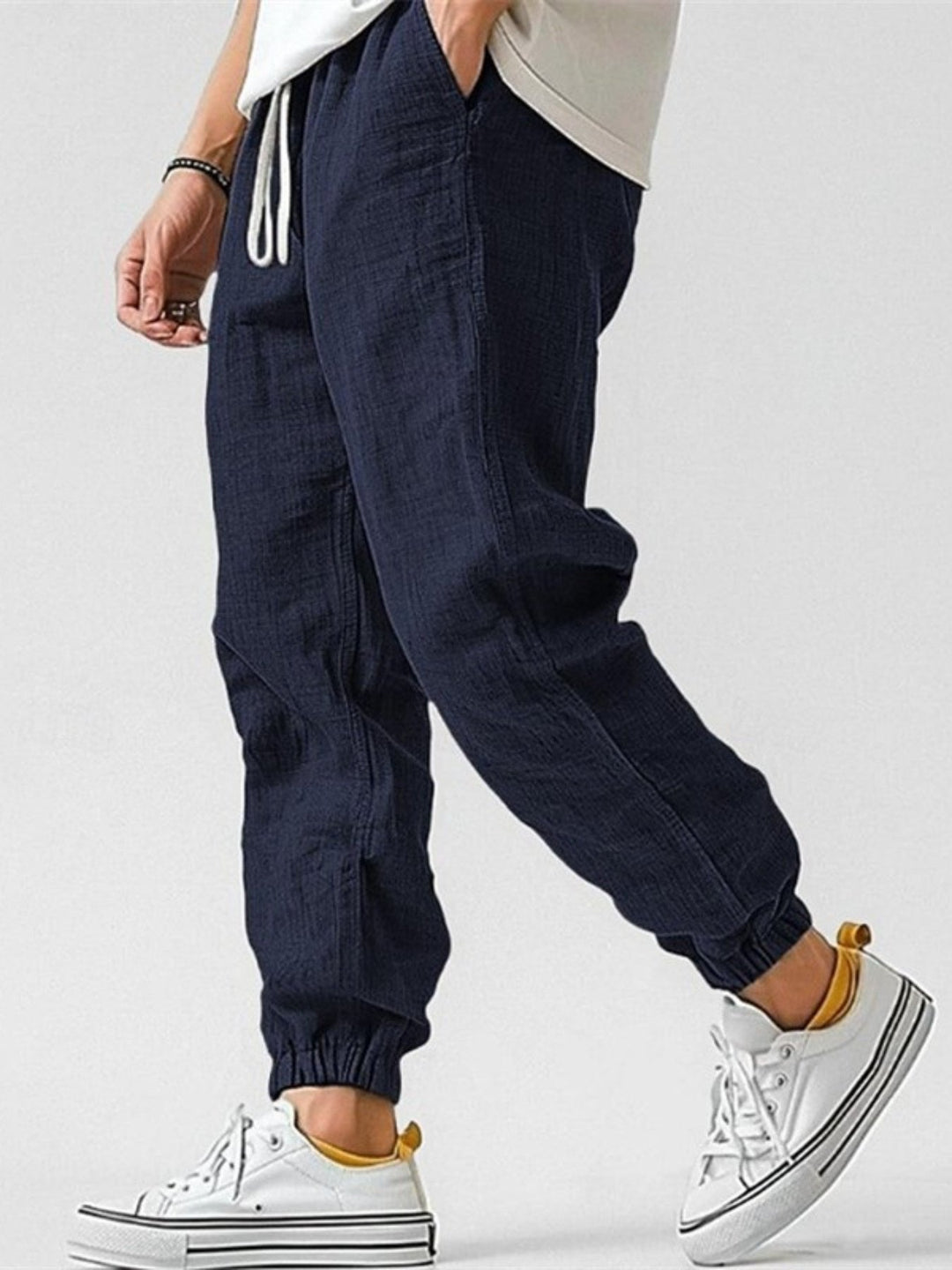Relaxed fit men's trackpants with tapered legs & cuffed bottoms, offering comfort for all-day wear.