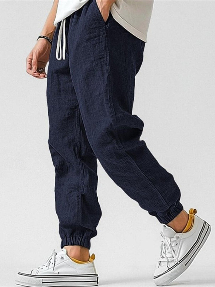 Relaxed fit men's trackpants with tapered legs & cuffed bottoms, offering comfort for all-day wear.