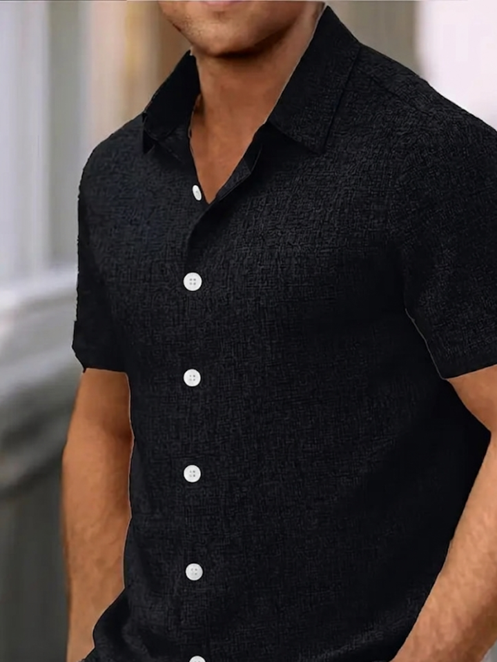 Man wearing a regular fit textured button-down polo shirt. Perfect short sleeve top for men's spring fashion.