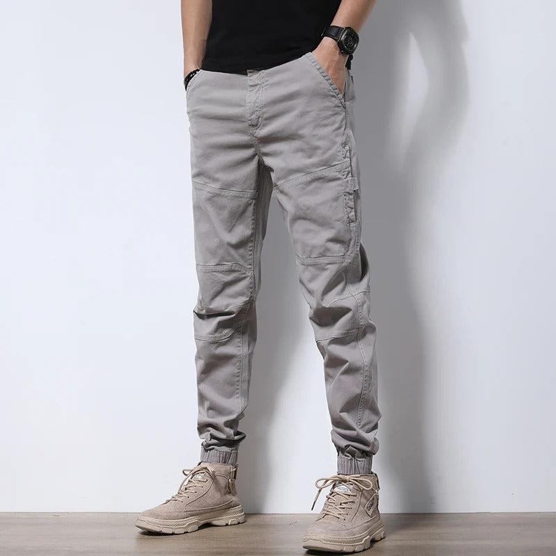 Model wearing Men's Urban Reinforced Cargo Joggers; showcasing tapered leg & comfortable, stretch fit.