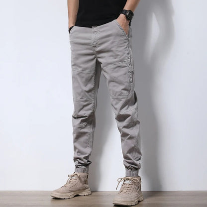 Model wearing Men's Urban Reinforced Cargo Joggers; showcasing tapered leg & comfortable, stretch fit.