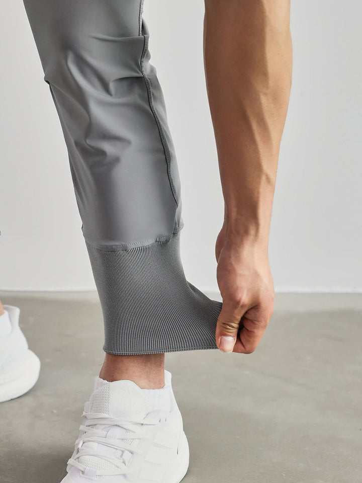 Side view of men's performance cargo joggers, olive, showing utility pockets & tapered leg.